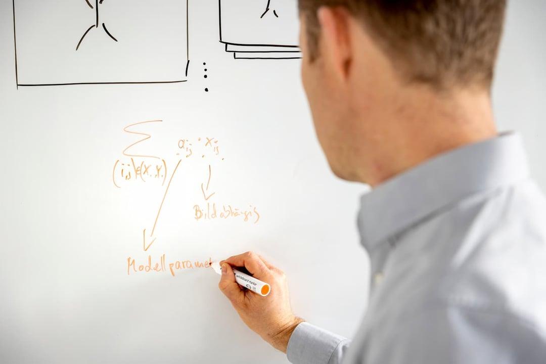 Formulas for machine learning project Man writing data on whiteboard